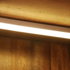 Cave à vin à plusieurs niveaux avec porte vitrée, plancher en bois et éclairage intégré