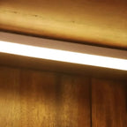 Cave à vin à plusieurs niveaux avec porte vitrée, plancher en bois et éclairage intégré