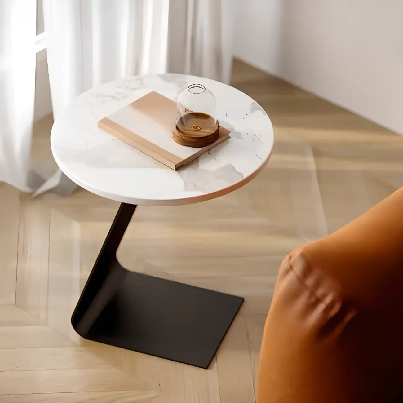 Table d'appoint ronde en marbre avec base en métal noir et forme en C, idéale pour un canapé.