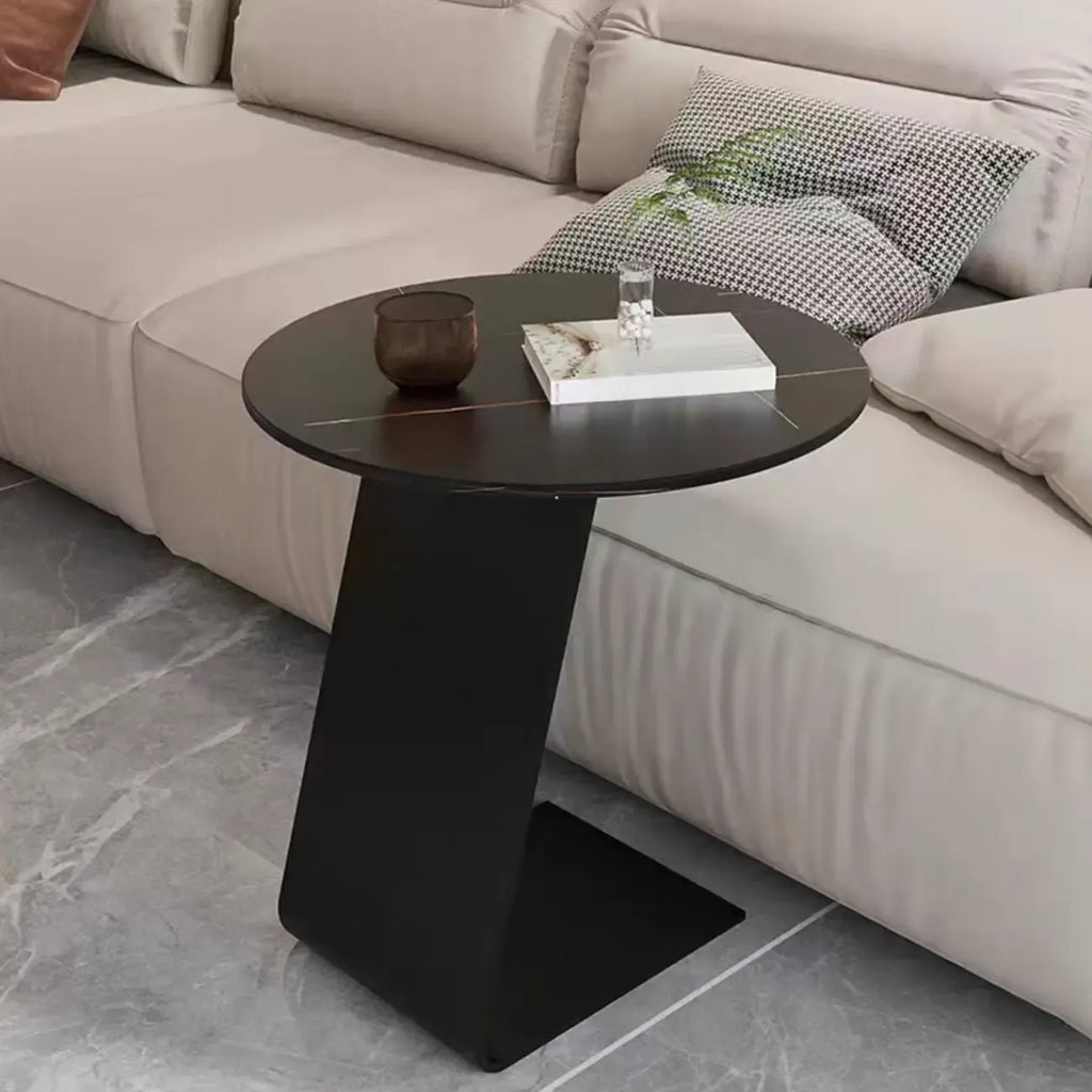 Table d'appoint ronde en marbre avec base en métal noir et forme en C, idéale pour un canapé.