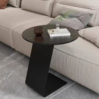 Table d'appoint ronde en marbre avec base en métal noir et forme en C, idéale pour un canapé.