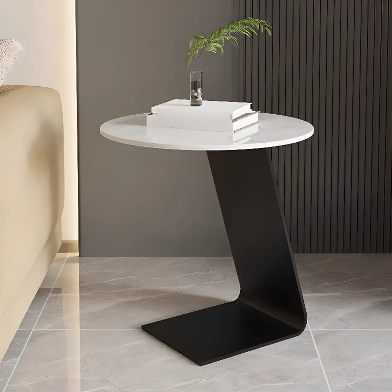 Table d'appoint ronde en marbre avec base en métal noir et forme en C, idéale pour un canapé.