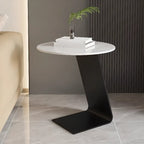 Table d'appoint ronde en marbre avec base en métal noir et forme en C, idéale pour un canapé.