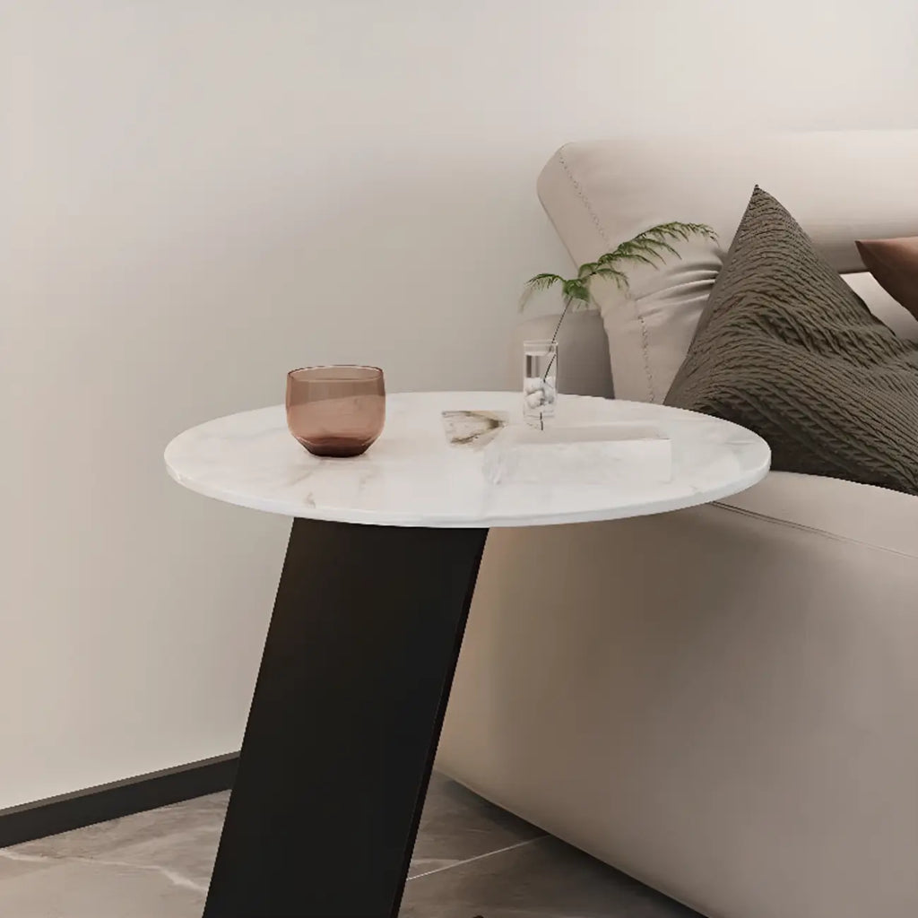 Table d'appoint ronde en marbre avec base en métal noir et forme en C, idéale pour un canapé.