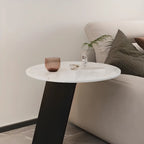 Table d'appoint ronde en marbre avec base en métal noir et forme en C, idéale pour un canapé.