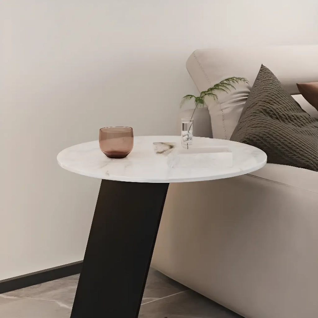 Table d'appoint ronde en marbre avec base en métal noir et forme en C, idéale pour un canapé.