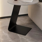 Table d'appoint ronde en marbre avec base en métal noir et forme en C, idéale pour un canapé.