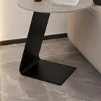Table d'appoint ronde en marbre avec base en métal noir et forme en C, idéale pour un canapé.