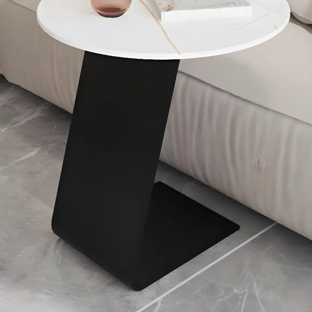 Table d'appoint ronde en marbre avec base en métal noir et forme en C, idéale pour un canapé.