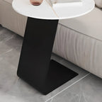 Table d'appoint ronde en marbre avec base en métal noir et forme en C, idéale pour un canapé.