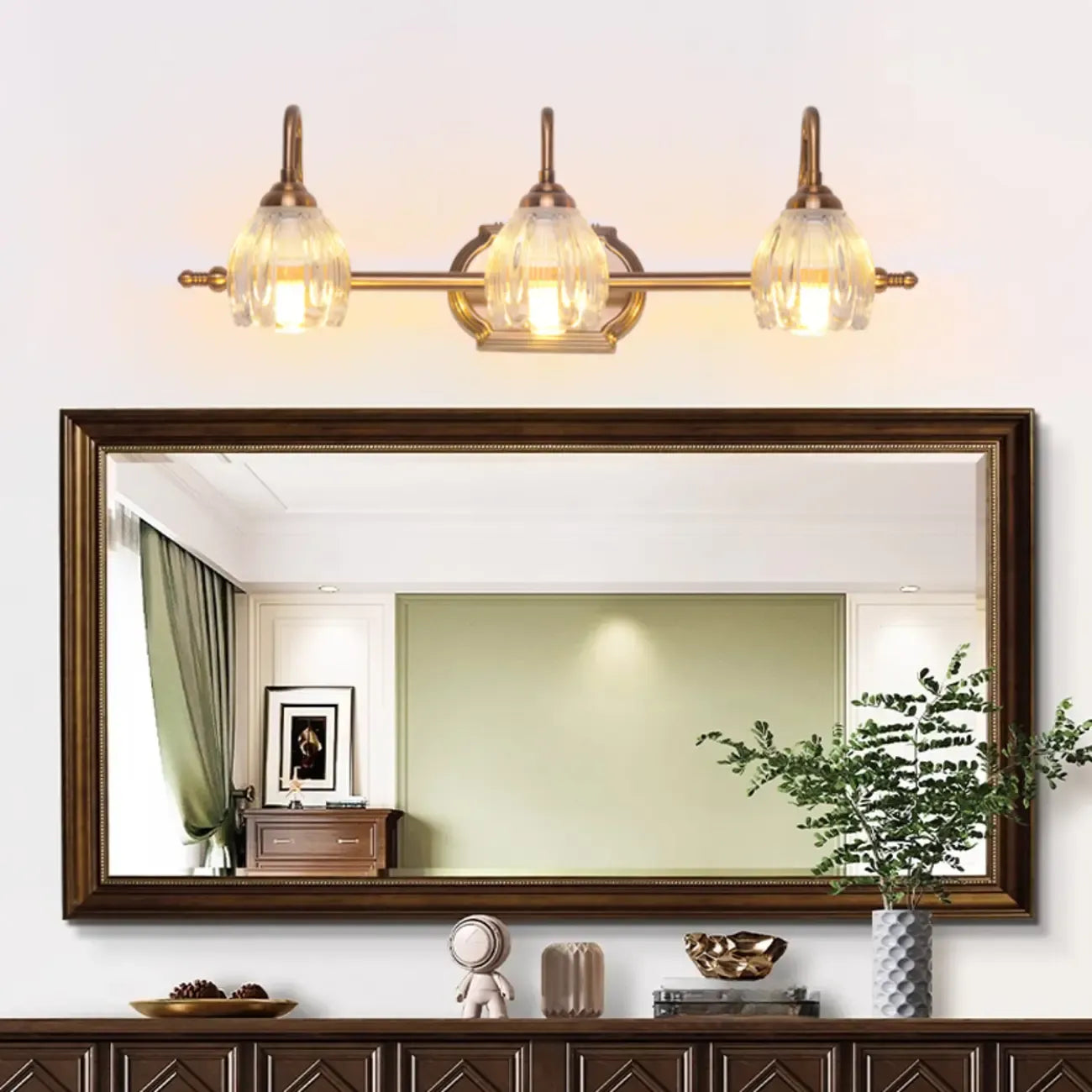 Applique murale moderne à trois lampes en laiton avec globe, à placer au-dessus du miroir.
