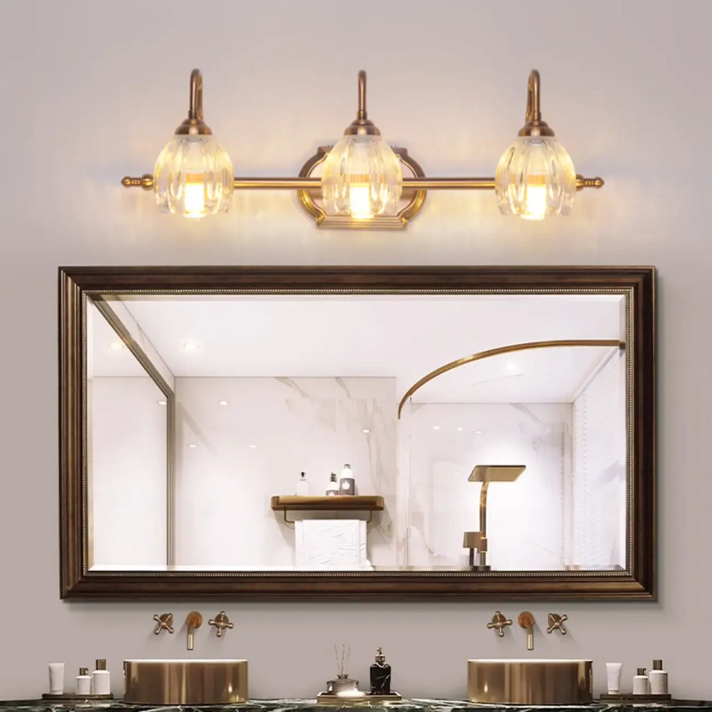Applique murale moderne à trois lampes en laiton avec globe, à placer au-dessus du miroir.