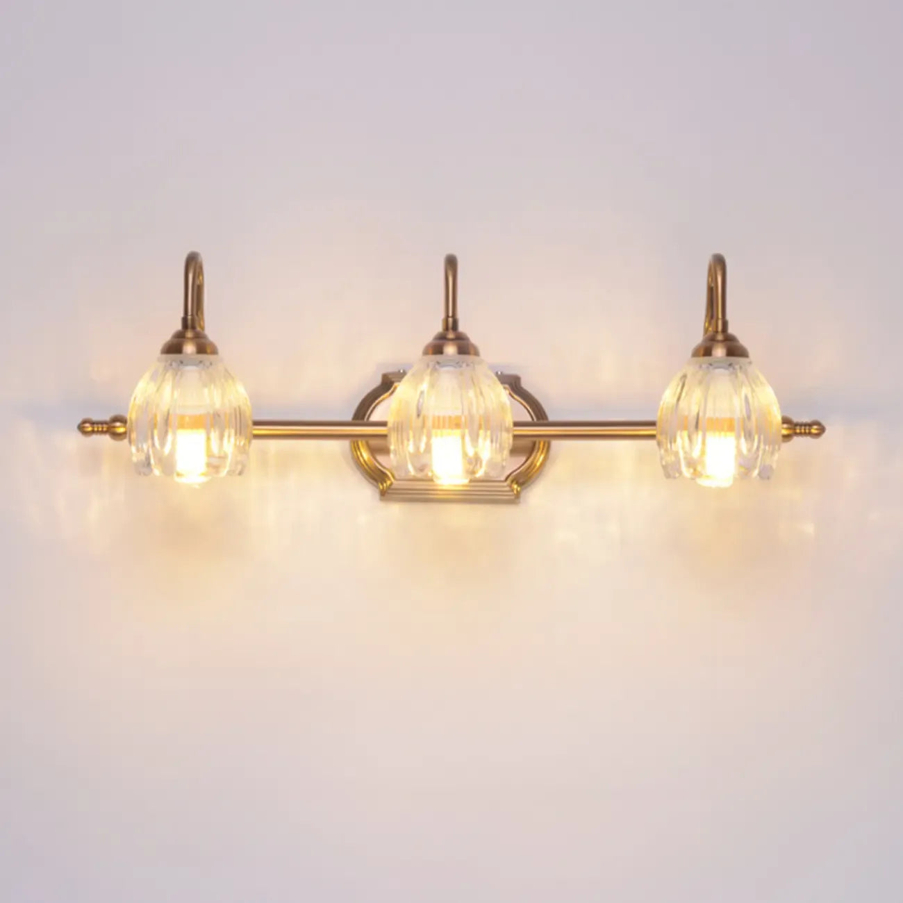 Applique murale moderne à trois lampes en laiton avec globe, à placer au-dessus du miroir.