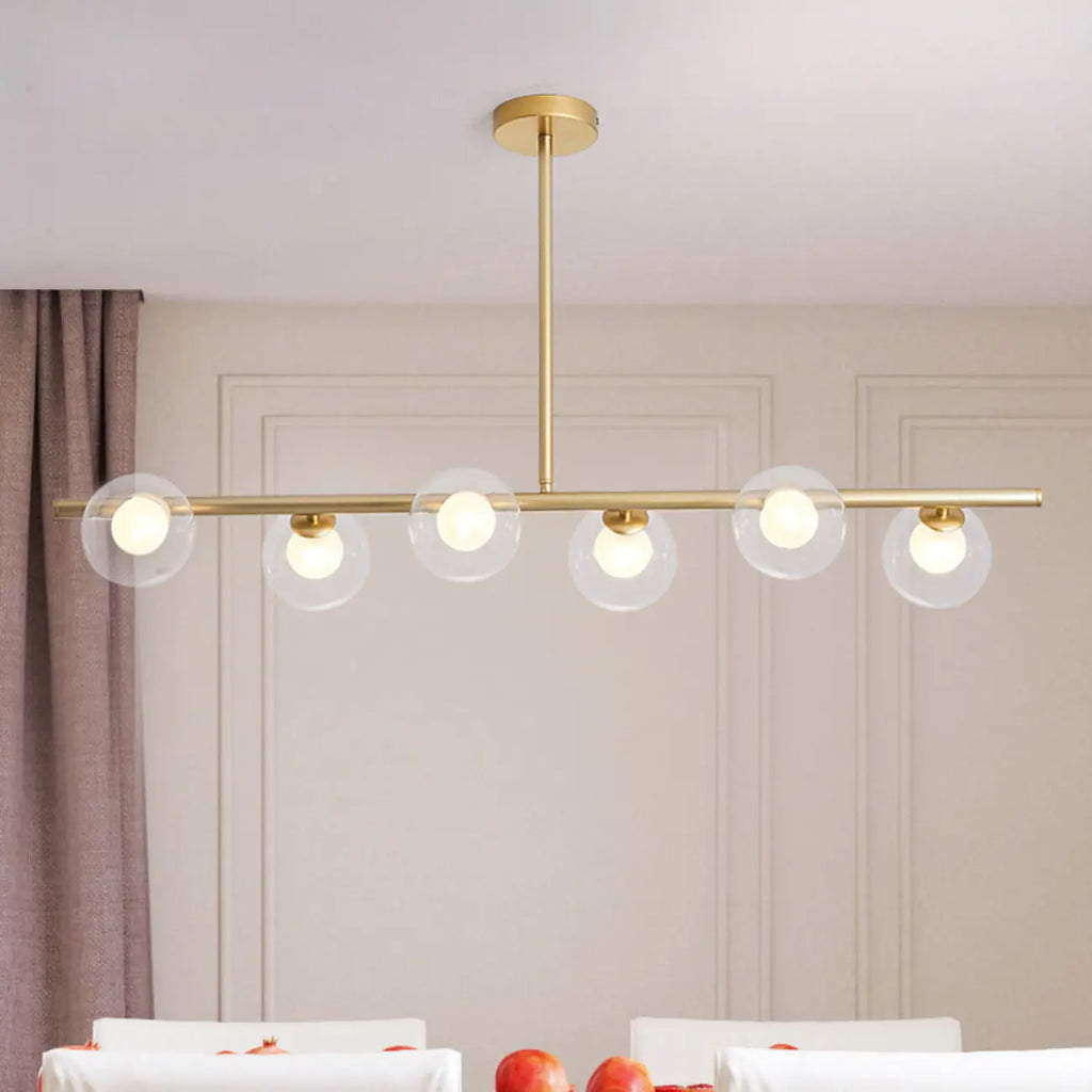 Applique murale linéaire dorée pour îlot central, avec 6 abat-jour en verre transparent.