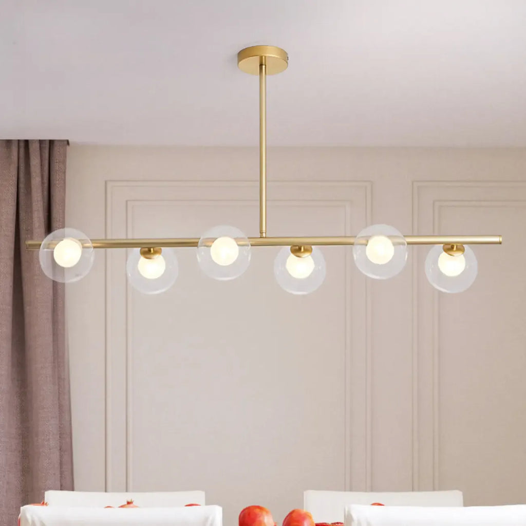 Applique murale linéaire dorée pour îlot central, avec 6 abat-jour en verre transparent.