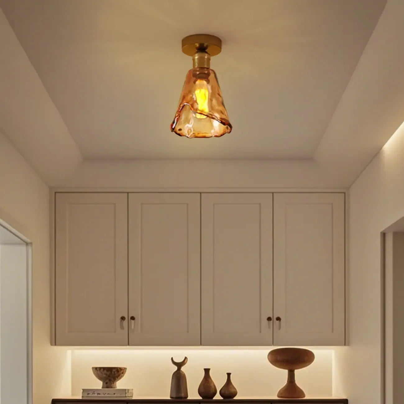 Plafonnier semi-encastré moderne en laiton et verre ambré, forme conique.