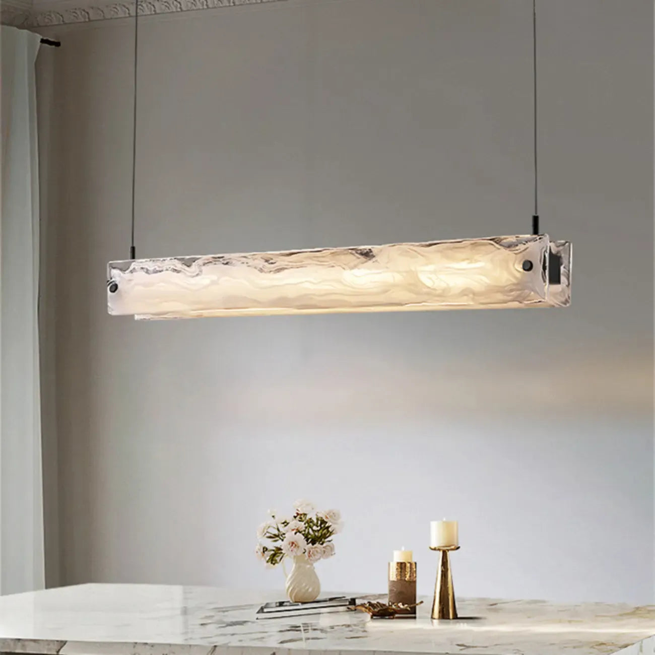 Suspension élégante en verre pour îlot de cuisine, avec éclairage LED à intensité variable.