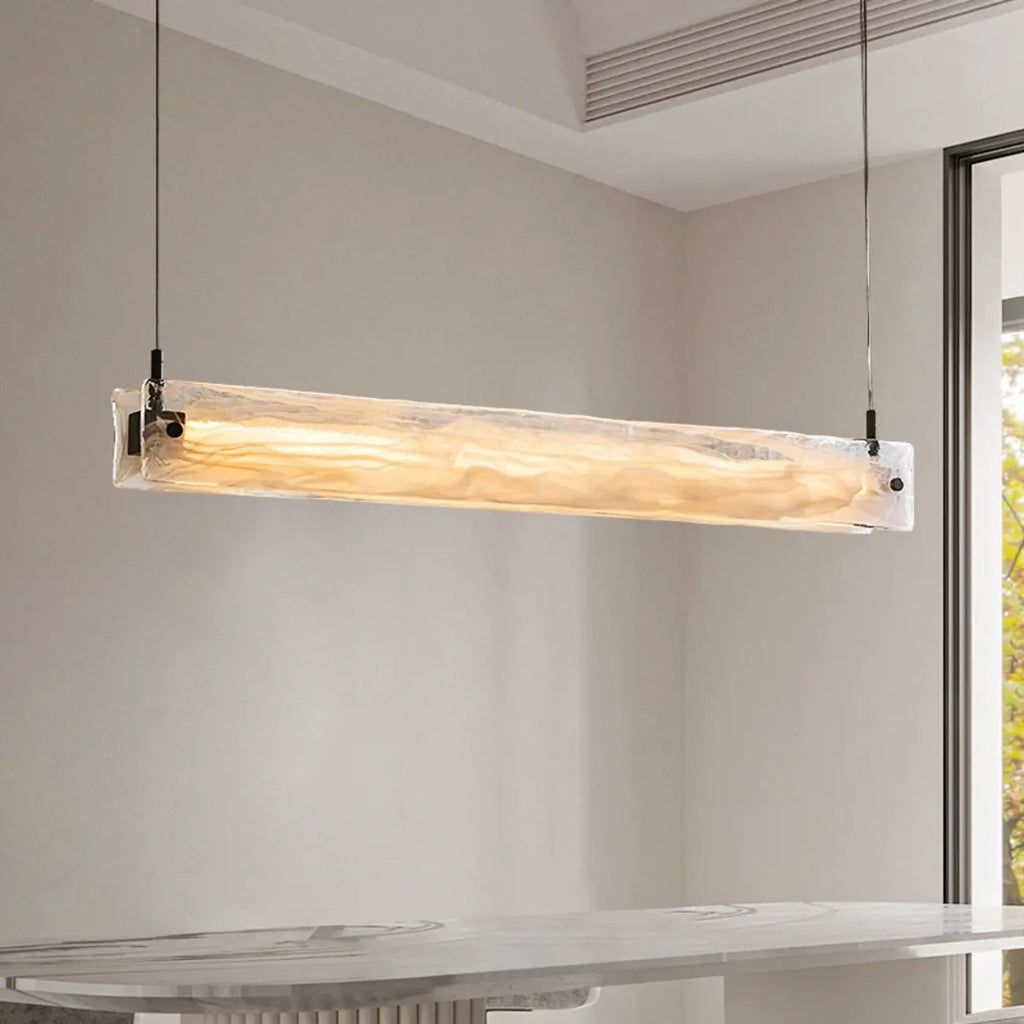 Suspension élégante en verre pour îlot de cuisine, avec éclairage LED à intensité variable.