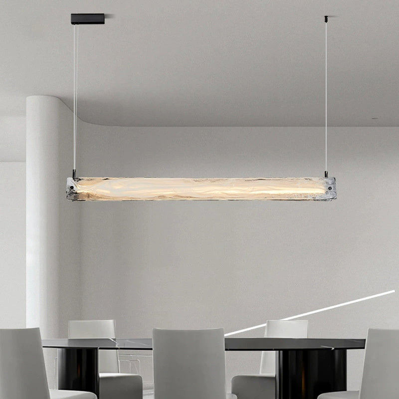 Suspension élégante en verre pour îlot de cuisine, avec éclairage LED à intensité variable.