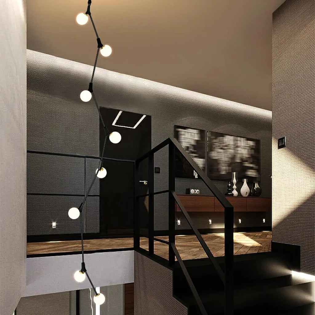 Lustre moderne doré à branches, globe en verre et tige de suspension pour escalier