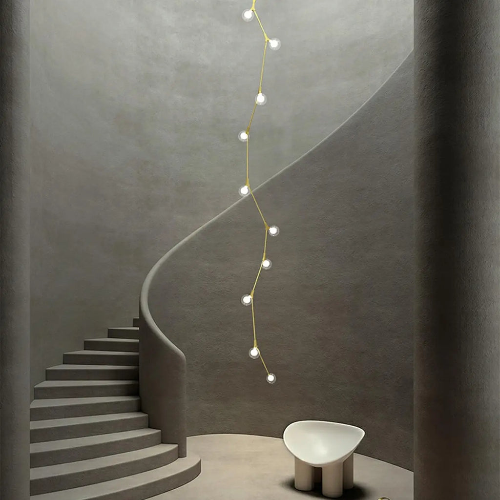 Lustre moderne doré à branches, globe en verre et tige de suspension pour escalier