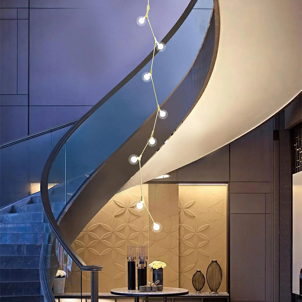 Lustre moderne doré à branches, globe en verre et tige de suspension pour escalier