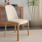 Chaise de salle à manger à dossier plein en bois crème et similicuir.