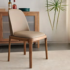 Chaise de salle à manger à dossier plein en bois crème et similicuir.
