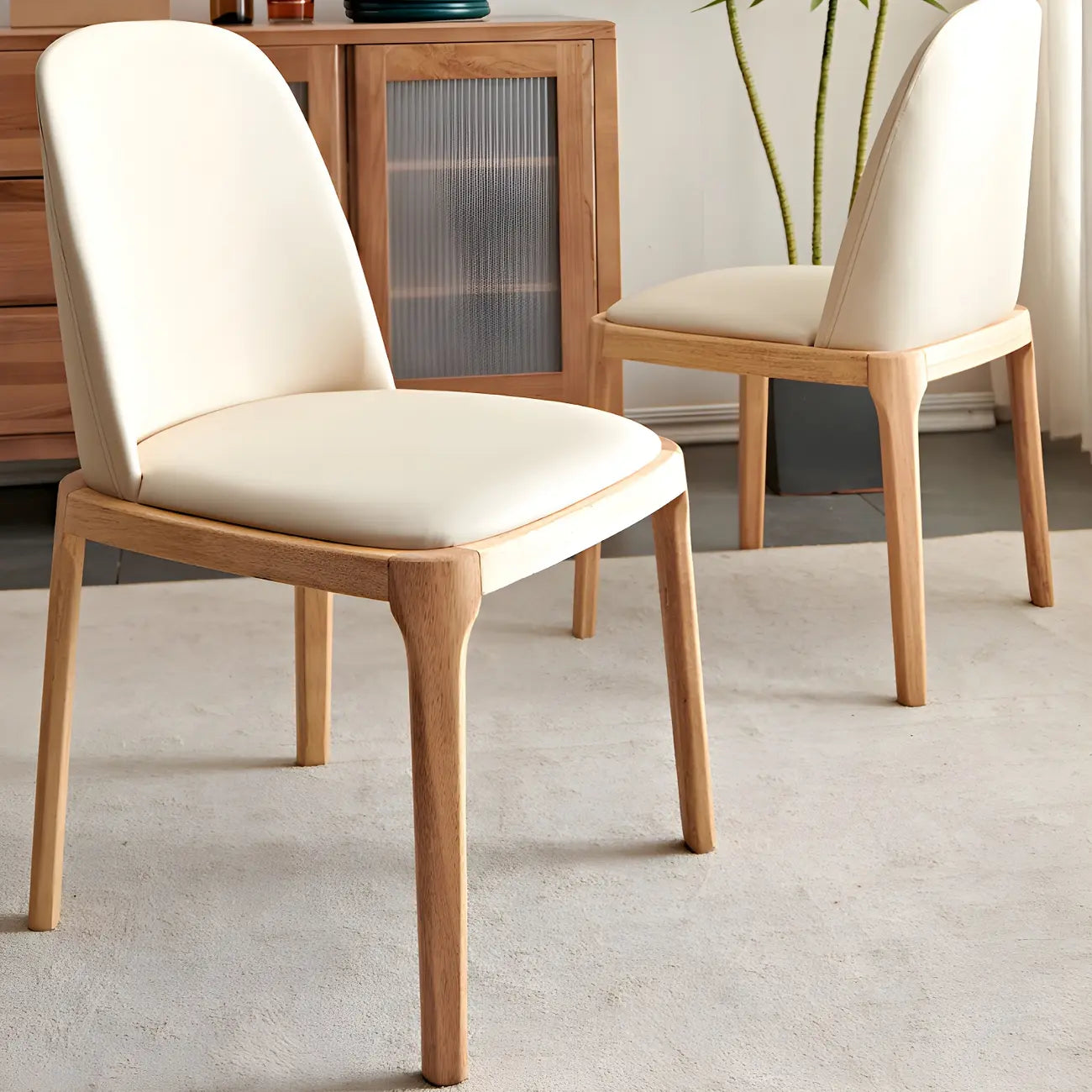 Chaise de salle à manger à dossier plein en bois crème et similicuir.