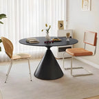 Table de salle à manger ronde avec plateau en pierre et piètement en métal, idéale pour les petits espaces.