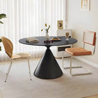 Table de salle à manger ronde avec plateau en pierre et piètement en métal, idéale pour les petits espaces.