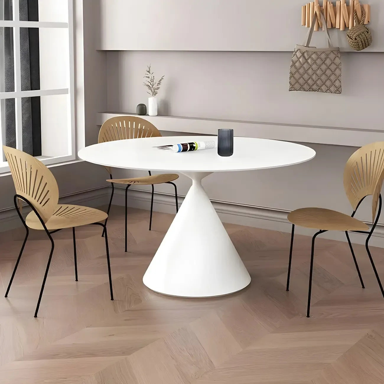 Table de salle à manger ronde avec plateau en pierre et piètement en métal, idéale pour les petits espaces.