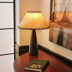 Lampe de table vintage élégante avec abat-jour en tissu et chaînette.