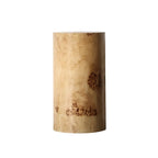 Table d'appoint cylindrique en bois clair avec piètement bloc.