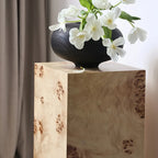 Table d'appoint cylindrique en bois clair avec piètement bloc.