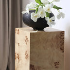 Table d'appoint cylindrique en bois clair avec piètement bloc.