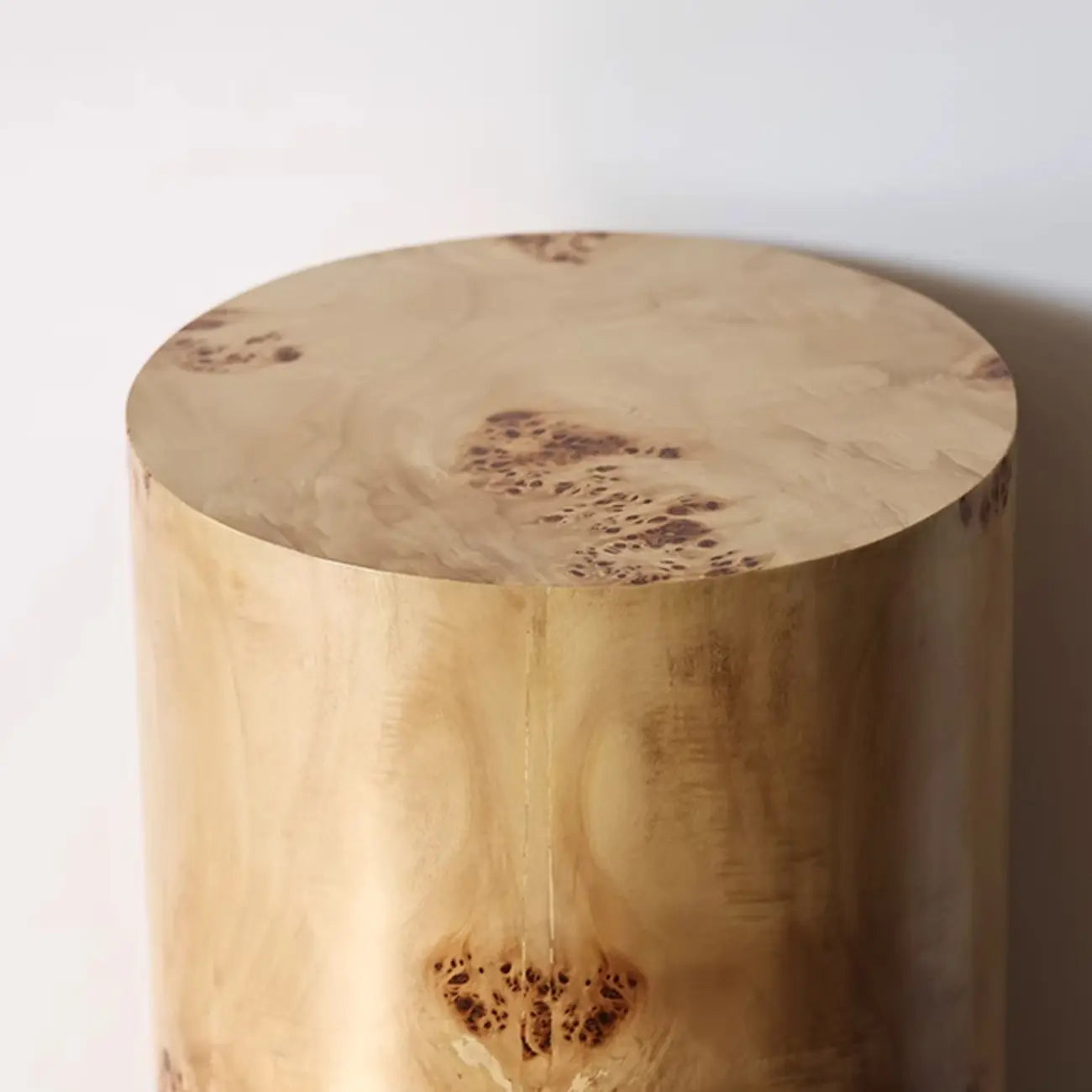 Table d'appoint cylindrique en bois clair avec piètement bloc.