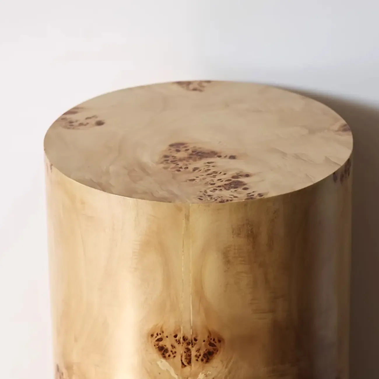 Table d'appoint cylindrique en bois clair avec piètement bloc.