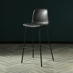 Tabouret de bar industriel en cuir avec structure métallique et repose-pieds
