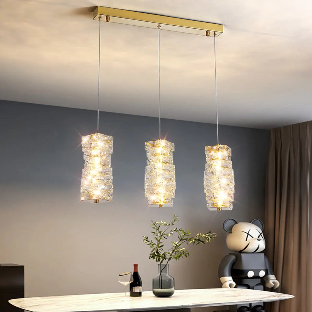 Suspension cylindrique en cristal pour îlot de cuisine, éclairage LED à intensité variable.