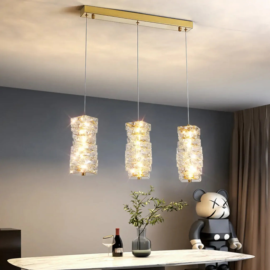 Suspension cylindrique en cristal pour îlot de cuisine, éclairage LED à intensité variable.