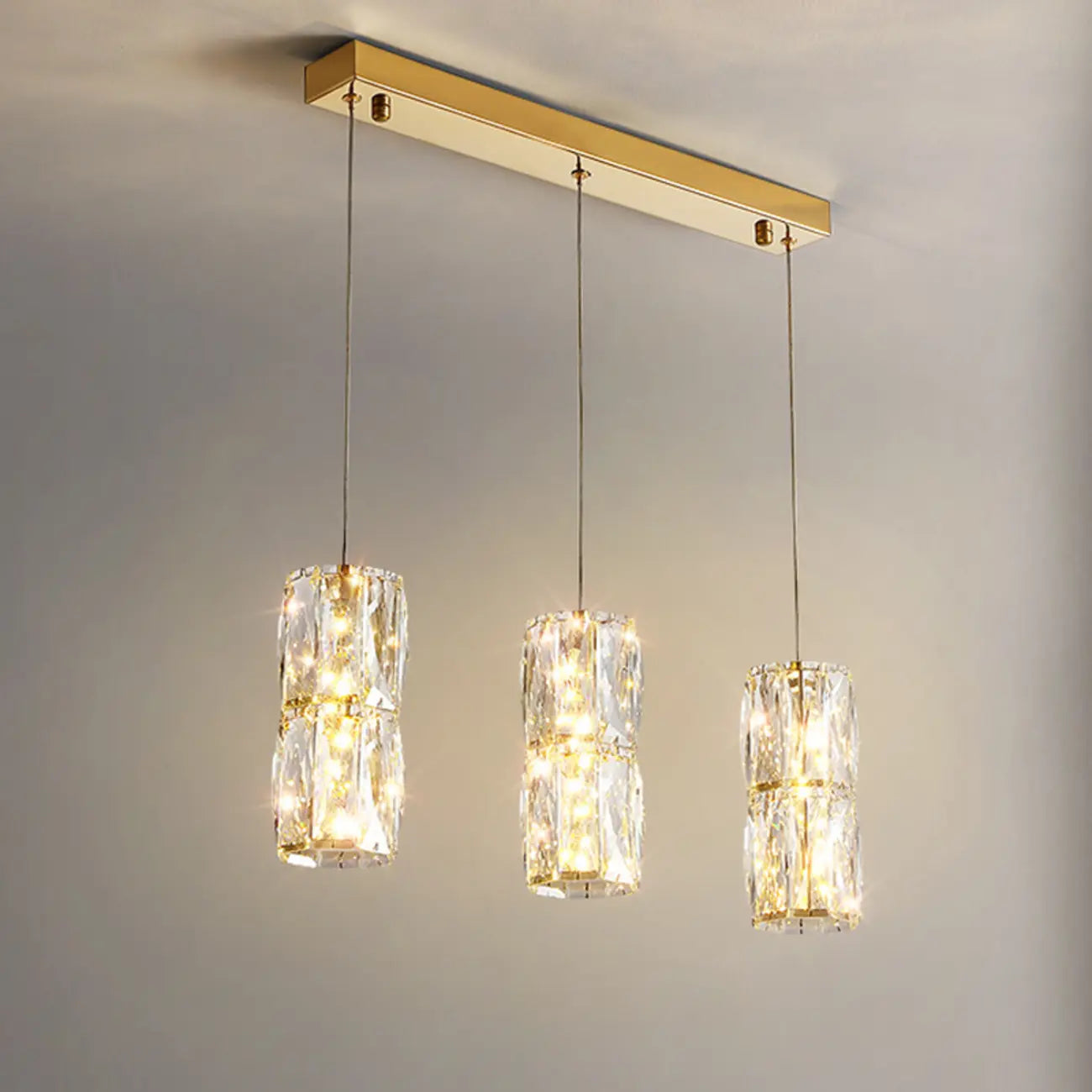 Suspension cylindrique en cristal pour îlot de cuisine, éclairage LED à intensité variable.