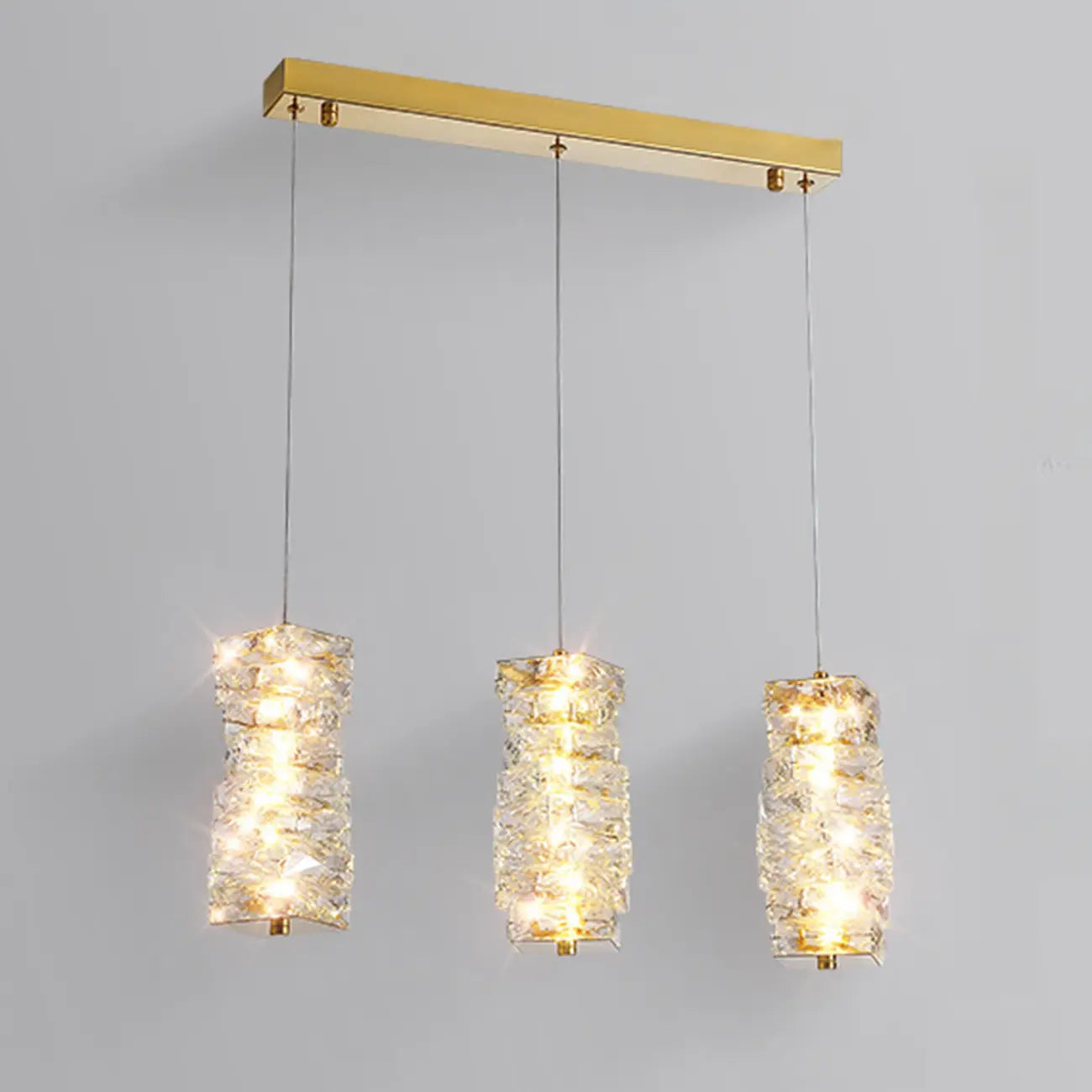 Suspension cylindrique en cristal pour îlot de cuisine, éclairage LED à intensité variable.