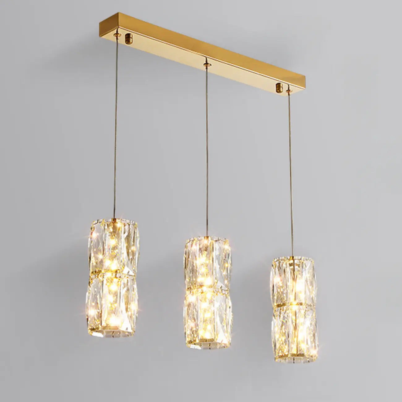Suspension cylindrique en cristal pour îlot de cuisine, éclairage LED à intensité variable.