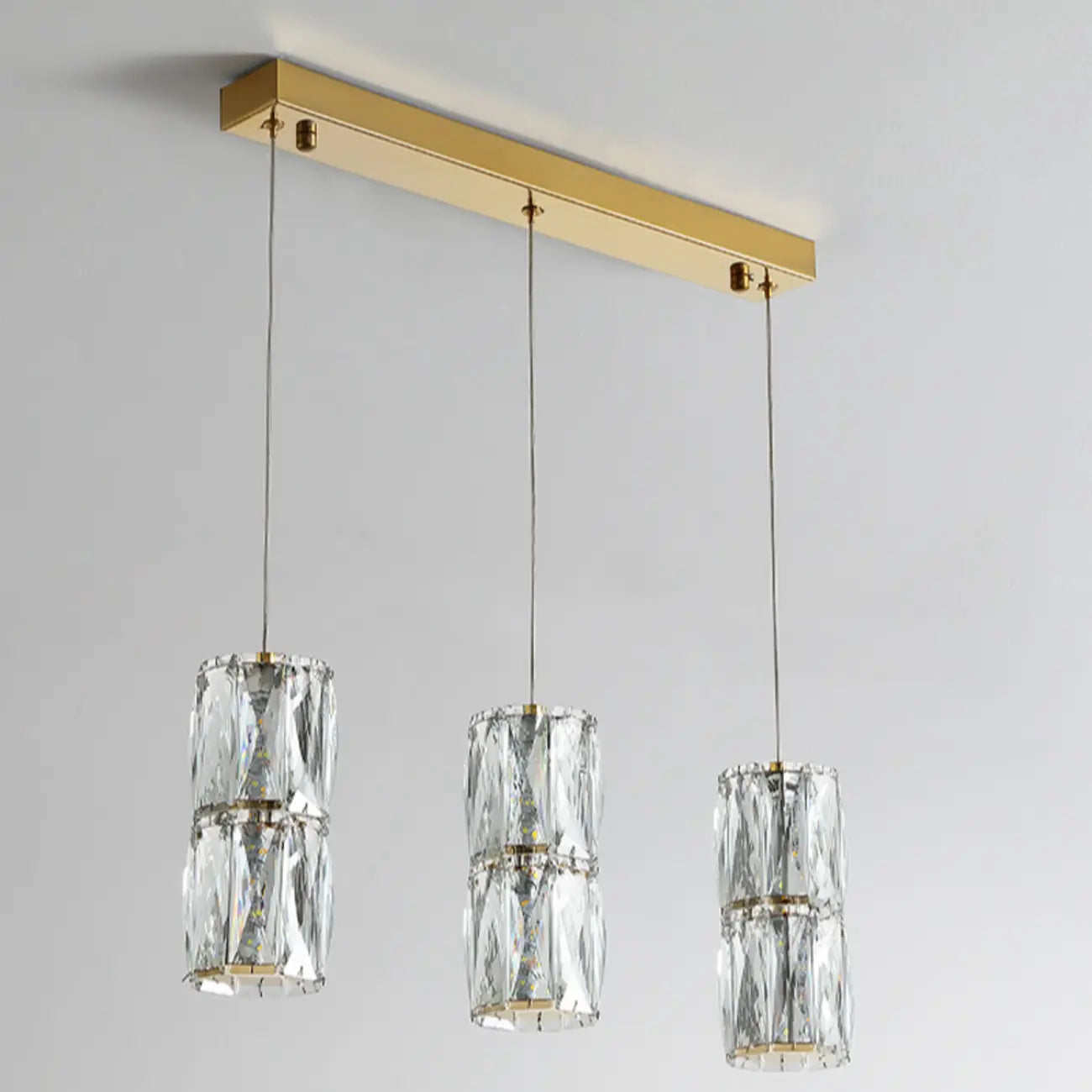 Suspension cylindrique en cristal pour îlot de cuisine, éclairage LED à intensité variable.