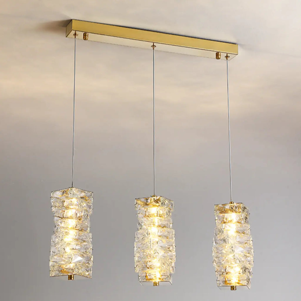 Suspension cylindrique en cristal pour îlot de cuisine, éclairage LED à intensité variable.