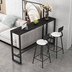 Table de bar moderne avec plateau en pierre noire, piètement à tréteaux et repose-pieds