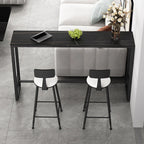 Table de bar moderne avec plateau en pierre noire, piètement à tréteaux et repose-pieds