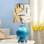 Lampe de table en verre bleu avec abat-jour en tissu à motif de feuilles