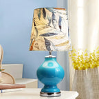 Lampe de table en verre bleu avec abat-jour en tissu à motif de feuilles